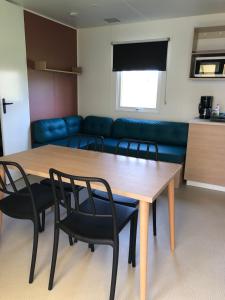 a living room with a table and chairs and a couch at Camping Moulin de Collonge in Saint-Boil