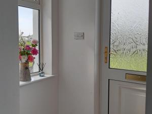 a door with a window and a vase of flowers at Cottage 465 - Cashel in Carna