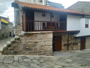 een huis met een balkon aan de zijkant bij Pensión rural Pallabarro in Allariz