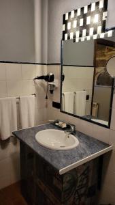 een badkamer met een wastafel, een spiegel en handdoeken bij Casa Rural del General Albelda in Villasante