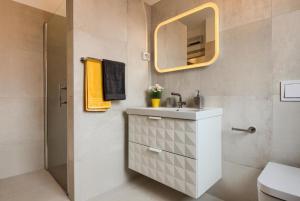 La salle de bains est pourvue d'un lavabo et d'un miroir. dans l'établissement Apartments DREAM IN ARENA 1 Pula Center FREE PARKING, à Pula