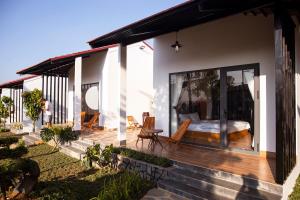 a house with a deck with a bed on it at Bảo Lộc Home in Bảo Lộc