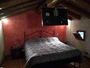 a bedroom with a bed and a red wall at Fienile ristrutturato in Zago