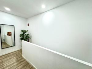 um corredor com uma parede branca e um espelho em Apartamentos Madrid Connection - Universidad by Oshun Apartments em Madri