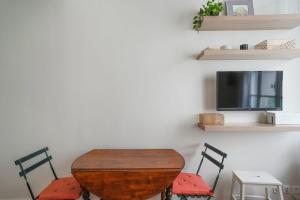 a room with a table and two chairs and a tv at Studio near Invalides in Paris