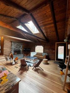 Woodchuck Sanctuary في Roxbury: غرفة معيشة مع موقد في كابينة خشب