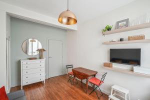 a white living room with a table and chairs at Studio near Invalides in Paris