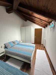 ein Schlafzimmer mit einem Bett und einer Holzdecke in der Unterkunft Apartma Popeye in Bovec