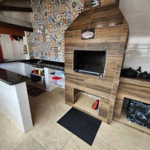 cocina con chimenea en el medio de una habitación en NOVO Casa com piscina e Wi Fi em Mongagua SP, en Praia Grande