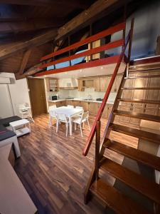 uma cozinha e sala de jantar com uma mesa e uma escada em Apartma Popeye em Bovec