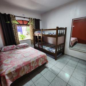 1 dormitorio con 2 literas y espejo en NOVO Casa com piscina e Wi Fi em Mongagua SP, en Praia Grande