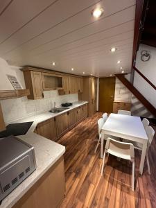 cocina con mesa, mesa blanca y sillas en Apartma Popeye, en Bovec