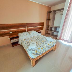 カマナにあるHotel Costa Surのベッドルーム1室(木製ヘッドボード付きのベッド1台付)