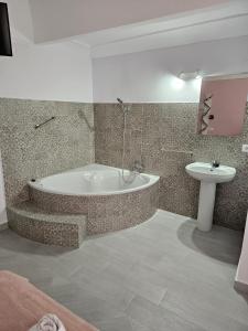 La salle de bains est pourvue d'une baignoire et d'un lavabo. dans l'établissement Pompeya Merida suite, à Mérida