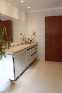 uma casa de banho com um WC e uma porta castanha em Casa bem localizada e de fácil acesso em Londrina