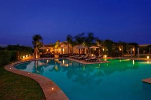 a large swimming pool in a resort at night at Villa cactus avec piscine privée in Riaïna