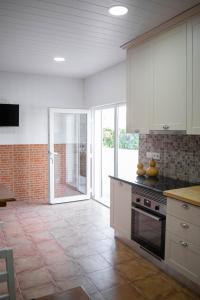 cocina con armarios blancos y suelo de baldosa en Alojamento Moinho d`Óbidos, en Óbidos