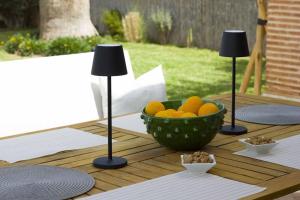 a bowl of oranges on a table with two lamps at Villa cactus avec piscine privée in Riaïna