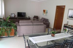 uma sala de estar com um sofá, uma mesa e cadeiras em Casa bem localizada e de fácil acesso em Londrina