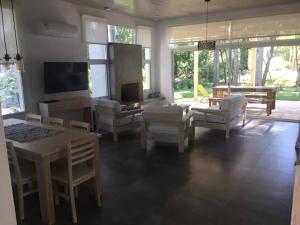 Il comprend un salon doté d'un mobilier blanc et d'une télévision. dans l'établissement Hermosa casa Minimalista en Solanas Vacation, à Punta del Este