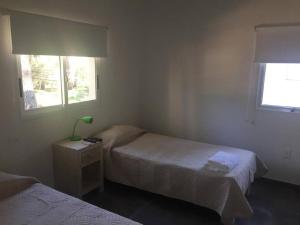 - une chambre avec 2 lits et une lampe sur une table de chevet dans l'établissement Hermosa casa Minimalista en Solanas Vacation, à Punta del Este