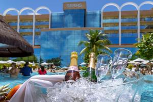 duas garrafas e duas taças de champanhe no gelo numa piscina em Serhs Natal Grand Hotel & Resort em Natal