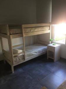 Cette chambre comprend 2 lits superposés et une table. dans l'établissement Hermosa casa Minimalista en Solanas Vacation, à Punta del Este