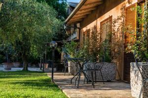 a patio with a table and chairs next to a house at Hotel & Spa Villa dei Mosaici in Spello