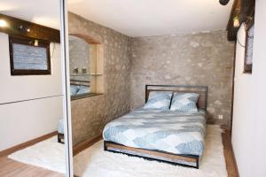 a small bedroom with a bed and a mirror at Quiet and bright nest near Perpignan in Pia