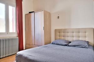1 dormitorio con 1 cama, armario y ventana en Quiet and bright nest near Perpignan, en Pia