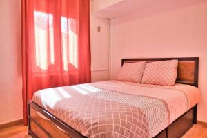 1 dormitorio con 1 cama con cortinas rojas y ventana en Quiet and bright nest near Perpignan, en Pia