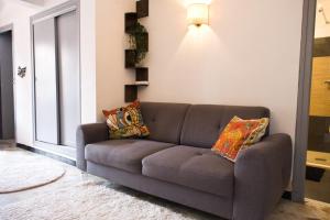 un sofá gris en una sala de estar con ventana en Quiet and bright nest near Perpignan, en Pia