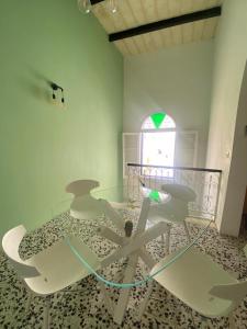 a glass table and chairs in a room with a window at Spacious room, king size bed, balcony, mirrors and luxury lights. in Mosta