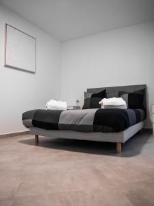 - un grand lit dans une chambre blanche avec une photo dans l'établissement Adalia lodge, à Yutz