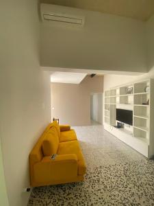 a living room with a yellow couch in a room at Spacious room, king size bed, balcony, mirrors and luxury lights. in Mosta