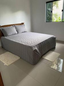 a bed in a white bedroom with a window at Apartamento, Salto del Guaira in Salto del Guairá