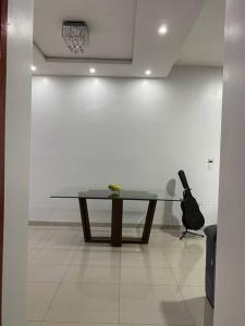 a glass table in a white room with a black purse at Apartamento, Salto del Guaira in Salto del Guairá