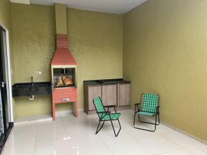 a living room with two chairs and a stove at Apartamento, Salto del Guaira in Salto del Guairá
