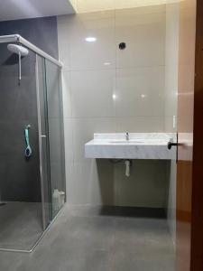 a bathroom with a sink and a glass shower at Apartamento, Salto del Guaira in Salto del Guairá