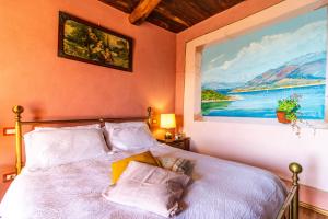 a bedroom with a bed with a painting on the wall at [Colazza] Appartamento Gelsomino - La Casa dei Sogni in Colazza