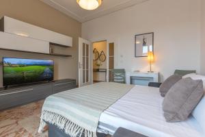 a bedroom with a bed and a flat screen tv at Ferrara Il Castello Dazzling Apartment in Ferrara