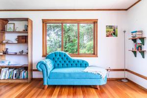 - un canapé bleu dans une chambre avec fenêtre dans l'établissement Refugio San Antonio - 1500 acre Private Preserve, à Guaria