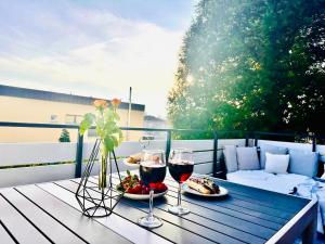 einen Tisch mit zwei Gläsern Wein und Essen in der Unterkunft 80qm Luxus Apartment mit großer Terrasse in Saarbrücken