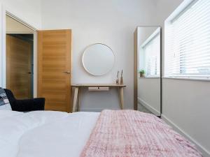 a bedroom with a bed with a mirror and a table at New Horizon in Sandown +51 photos