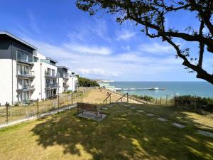 a park bench in front of a building overlooking the ocean at New Horizon in Sandown
