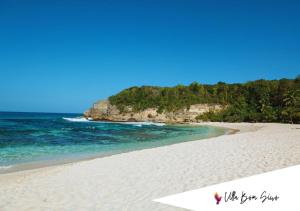 une plage de sable blanc avec des arbres et l'océan dans l'établissement Villa Bom Siwo: Anse Bertrand, à Anse-Bertrand