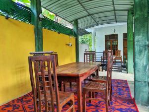 a wooden table and chairs on a patio at Golden Pearl Safari Villa in Udawalawe