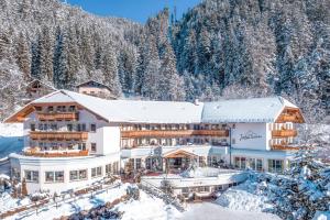 um hotel com montanhas cobertas de neve ao fundo em Hotel Marica em Eggen