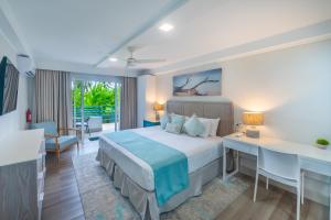 a bedroom with a bed and a desk in a room at Blue Haven Holiday Apartments in Christ Church