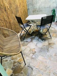 two chairs and a table on a stone patio at St-Pierre Maison de Ville 4 pers - Plage à 50m in Saint-Pierre